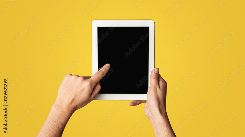 Poster young man touching blank screen of tablet computer on light background, closeup. mockup for design. 