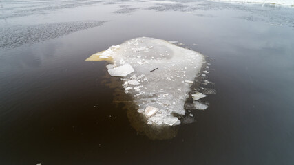 Small ice block sits on top of a large body of water