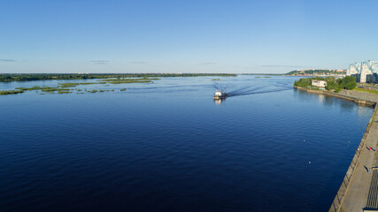 Boat is traveling on a river with a blue sky in the background