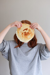 happy girl cover face with pancake. celebrate russian holiday Maslennica. Mock up, copy space