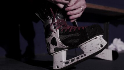 Lacing up hockey skates close up on feet