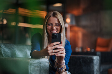 Chic Businesswoman Snapping a Selfie on a Comfortable Sofa