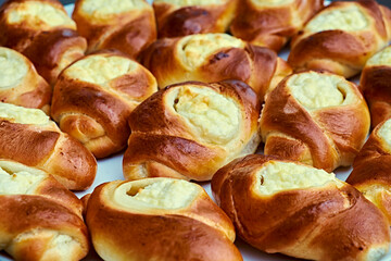 Freshly baked golden-brown pastries with a creamy cheese filling, displayed close-up on a plate