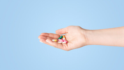 Virus treatment or suicide concept. Girl holding pile of pills on white background, close up