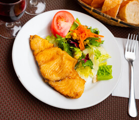 Delicious fried fish, typical andalusian food. Spanish dish with dogfish served with fresh salad on white plate