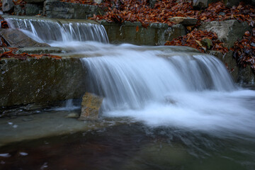 Obraz premium A small waterfall by the river. 