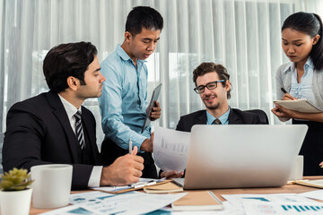 Diverse group of business analyst team analyzing financial data report paper on office table. Chart and graph dashboard by business intelligence analysis for strategic marketing planning Meticulous