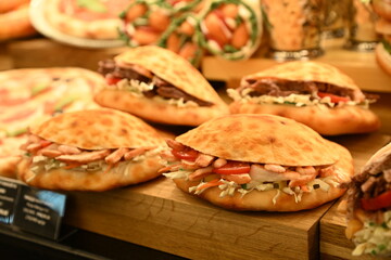 Mouth-watering meat and vegetable rolls, salmon and ham sandwiches; nuggets in the cafe window