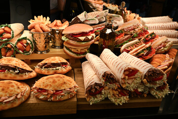 Mouth-watering meat and vegetable rolls, salmon and ham sandwiches; nuggets in the cafe window