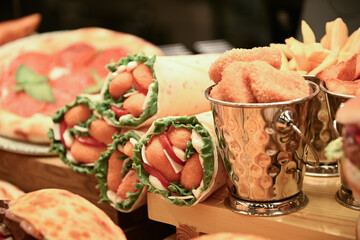 Mouth-watering meat and vegetable rolls, salmon and ham sandwiches; nuggets in the cafe window