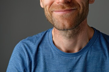 Fototapeta premium Close up portrait of smiling handsome guy in blue t shirt isolated on gray background