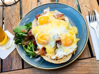Uitsmijter. Netherlands scrambled eggs with bacon and herbs on the table