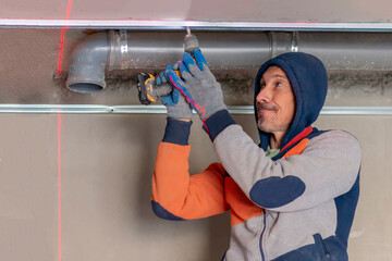 Fototapeta premium Apartment renovation. Laser level for marking material. Builders apartment improvement or restoration works.