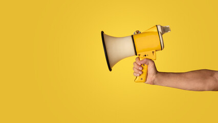 Advertising concept. Millennial guy holding loudspeaker on orange background, closeup. Panorama