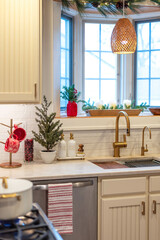 Cozy small kitchen decorated for Christmas with pine branches and touches of red decor