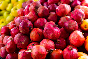 Fresh ripe pomegranates in box ready for sale at market stall
