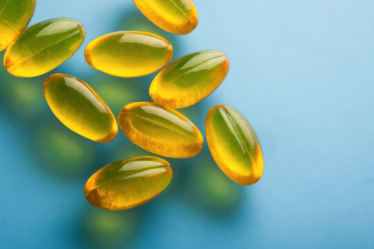Transparent gel capsules on blue background for health concept