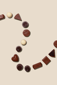 Top view of assorted chocolate truffles on a beige background