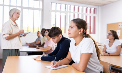 Portrait of attentive positive young female student studying on training session in lecture class