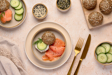 Food photography of sandwich with keto buns, low-carb bread, psyllium husk, sunflower, pumpkin and sesame seeds, almond flour, ketogenic diet, smoked salmon, soft cheese, cucumber