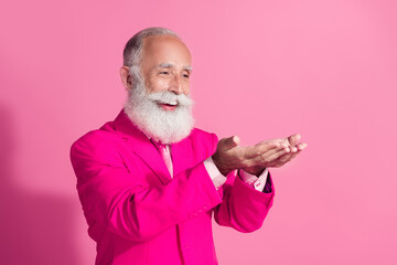 Photo of cool pensioner santa claus male macho hold empty space dressed pink suit isolated pastel...