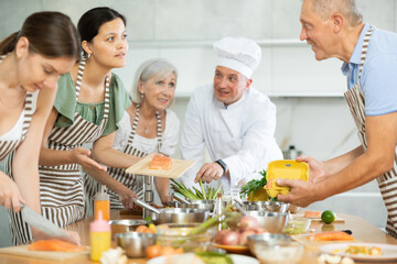 Professional personal chef cook in customer private kitchen house giving a cooking lesson to people at home