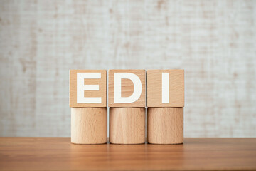 There is wood cube with the word EDI. It is an abbreviation for Electronic Data Interchange as...