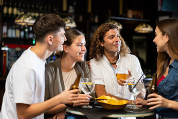 Happy friends drinking beer and chatting with each other in a restaurant