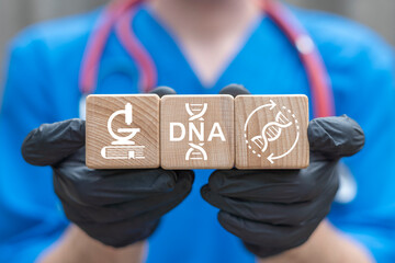 Doctor holding wooden blocks with icons sees text: DNA. DNA Healthcare Innovation concept. Mysterious DNA double helix. Genome research and modification. Conceptual genetics information.