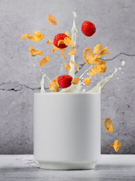 Creative splash composition with cereal, milk, and raspberries