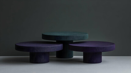 Three round textured purple and teal pedestals on grey background.