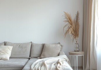 Minimalist living room interior with a grey sofa. beige throw blanket. and a vase of dried pampas grass on a side table
