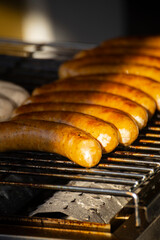 On the grill, sausages of various colors are neatly arranged