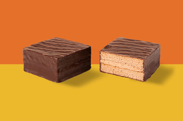 Layer cake with chocolate candy isolated on orange background.