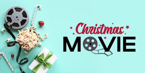 Bucket of popcorn with film reel, candy canes and gift box on turquoise background