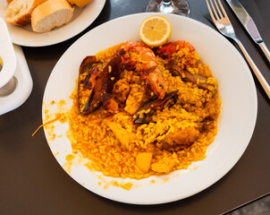 Delicious rice paella with meat, chicken and seafood served on plate