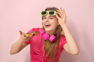 Teenage girl eating delicious pizza Margherita on pink background