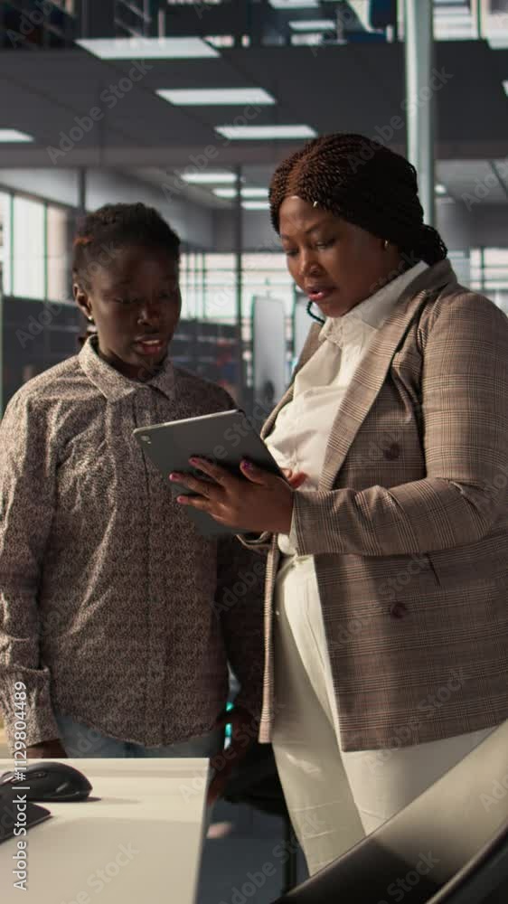 Poster vertical video business associates reviewing objectives data and performance metrics in a modern off