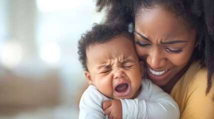 Fototapeta premium Desperated Afro American Mother comforting her crying baby suffering from teething pain