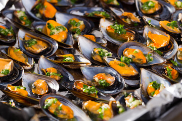 Baking tray with fresh clams in shells with garlic and parsley