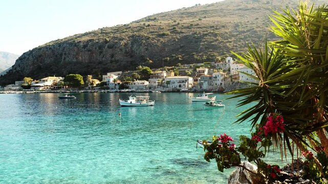 View across azure Mediterranean water to Limeni Greek fishing village