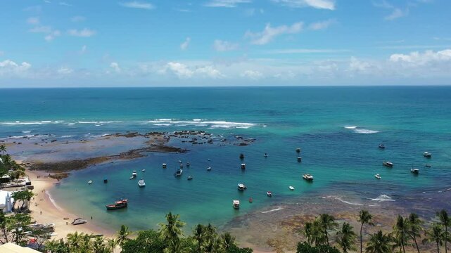 Fantastic aerial view of Praia do Forte beach with small boats turquoise waters and a cute village near Salvador. Praia do Forte, Bahia, Brazil 