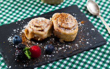Appetizing Cinnabons served with fresh berries on slate