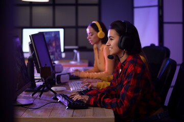 Young woman playing computer game in club at night