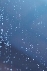 A moody and atmospheric image of raindrops on a windowpane, suggesting a rainy day. The image creates a sense of nostalgia and introspection.