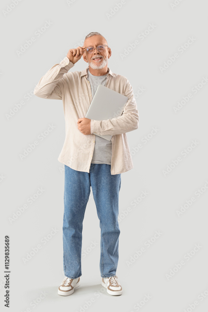 Poster mature programmer with laptop on light background