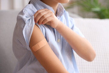 Cute girl with medical patch after vaccination at home, closeup