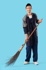 Male scavenger with broom sweeping on blue background