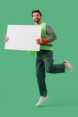 Male scavenger with blank poster jumping on green background