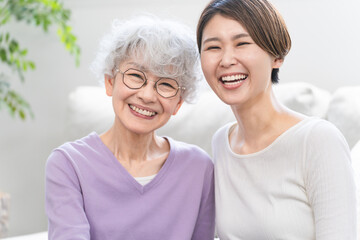並んで座る若い女性とシニア女性	
